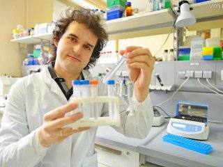 Старший научный сотрудник химического факультета МГУ и Сколковского института науки и технологий Илья Остерман демонстрирует пробирку с полученной бактериальной культурой / Фото: Александр Кожохин, «Вечерняя Москва»