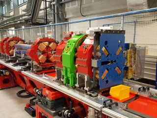 В процессе сборки магнитной системы специалисты устанавливают магниты на специальные столы - гирдеры. Октупольный магнит - на переднем плане (синий). Автор фото Сергей Гуров