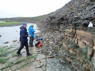 Участники экспедиции за работой по описанию геологического строения древнейших пород одного из береговых обнажений р. Хорбусуонки. Иллюстрация предоставлена Д.В. Метелкиным