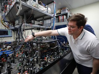 Научный сотрудник Центра квантовых технологий МГУ Иван Борисович Бобров показывает журналистам системы квантового компьютера на атомной платформе. Фото: Елена Либрик / «Научная Россия»