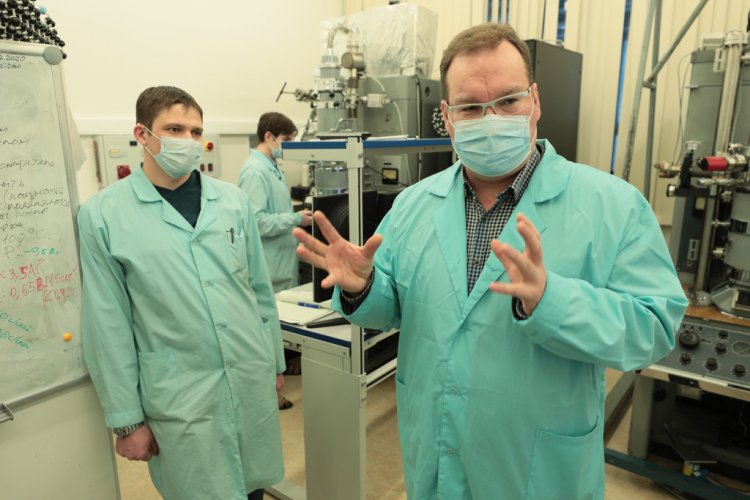 Заведующий лабораторией Дмитрий Щеглов с молодыми коллегами демонстрирует уникальную научную установку — комплекс сверхвысоковакууумной отражательной микроскопии