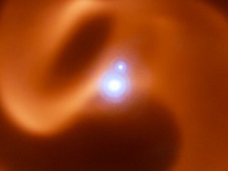 Ученые ESO получили уникальное изображение тройной звездной системы змеевидной формы