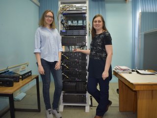 Юлия Захарова и аспирант Мария Сахно изучают оборудование для решения задач по ускорению запуска работы приложений. Источник Юлия Захарова