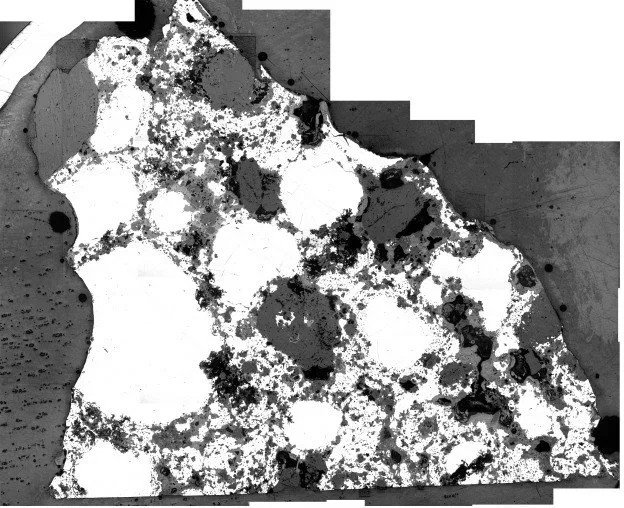 Оптическое изображение основного вещества (L1) богатого металлом (белый цвет) хондрита SG 013. Силикатные хондры и их класты — серый цвет, выкрашенное вещество — черный цвет