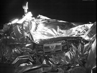 Снимок получен камерой комплекса СТС-Л на борту космического аппарата «Луна-25» 13 августа 2023 г. во время перелёта к Луне. Видны эмблема миссии и ковш лунного манипуляторного комплекса ЛМК (слева вверху). Фотография ИКИ РАН