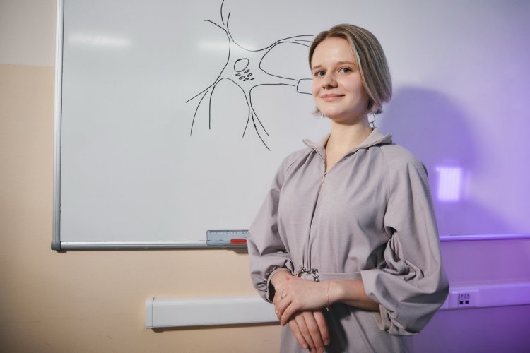 К.И. Морозова со схематичным изображением нейрона.  Фото: Елена Либрик / «Научная Россия»