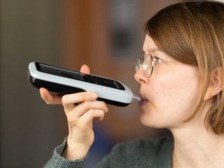 Пользователь проводит измерение с помощью смартфона и анализатора ацетона в выдыхаемом воздухе. Фото: Alivion AG / Andreas Güntner